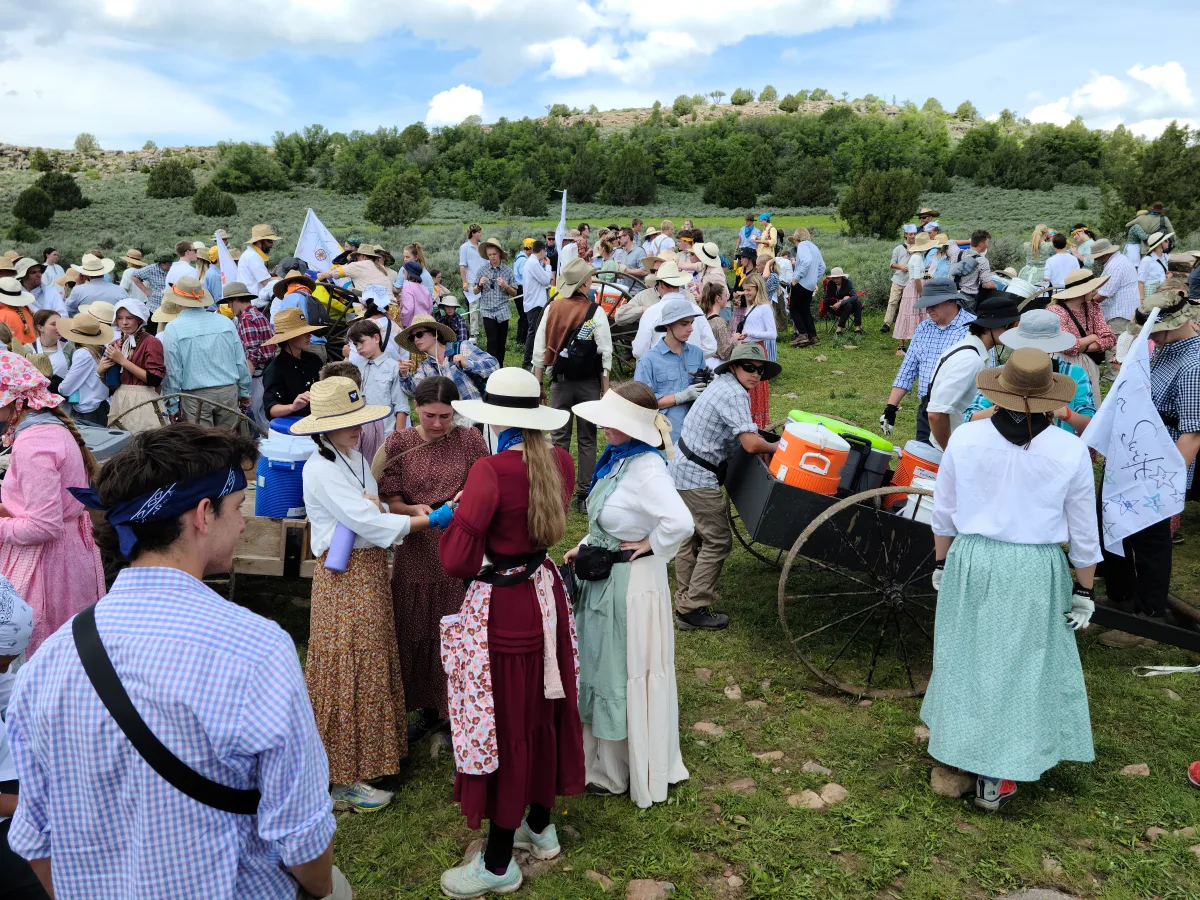 Young women in pioneer trek clothing: long-sleeved ankle-length dresses, aprons, and bonnets