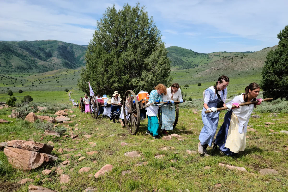 Young women pulling handcarts during the women's pull on a pioneer trek